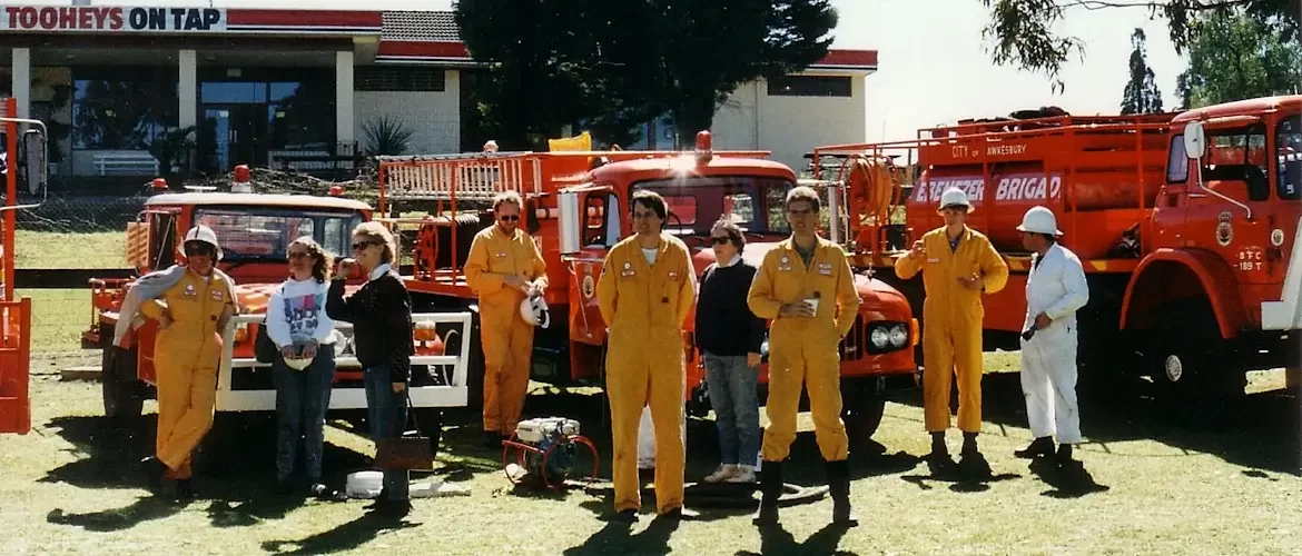 Freemans Reach firefighters in orange uniforms in front of red fire trucks